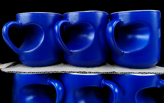 Blue mugs on supermarket shelf. Two arrangement of new cups in the store