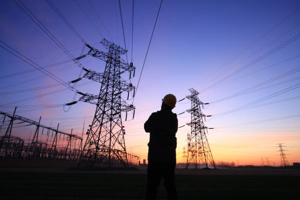 istock Electricity workers and pylon silhouette 1221272022