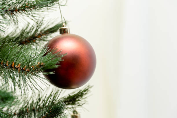 istock Christmas ball hanging on a christmas tree branch with copy space on white background 1221272808