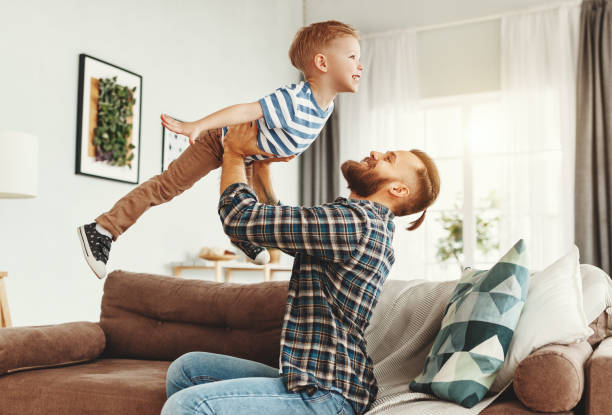 istock Happy man having fun with son at home 1221272820