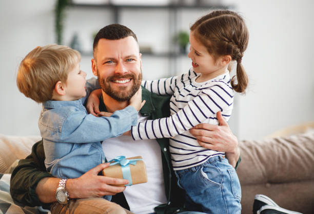 istock Little siblings congratulating happy father at home 1221272826