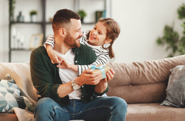 istock Cute girl hugging happy father with gift 1221273477