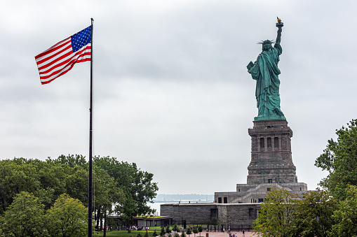 New York, NY / USA - July 19, 2019: Liberty Island is a federally owned island in Upper New York Bay in the United States. Its most notable feature is the Statue of Liberty, a large statue by Frédéric Auguste Bartholdi that was dedicated in 1886.