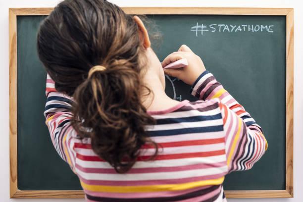 istock little girl drawing a coronavirus on a blackboard 1221278677