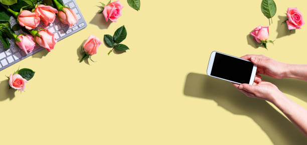 istock Woman holding her smartphone with pink roses 1221281128