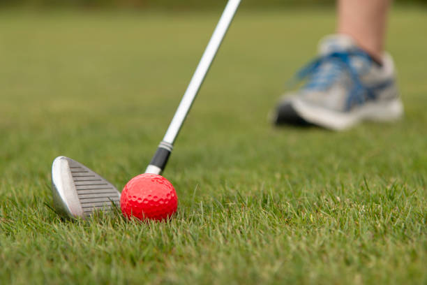 istock Getting ready to hit a red golf ball on fairway with iron club 1221282310
