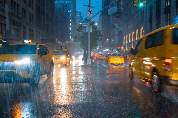 taxis pluvieux à manhattan - night wet road street photos et images de collection