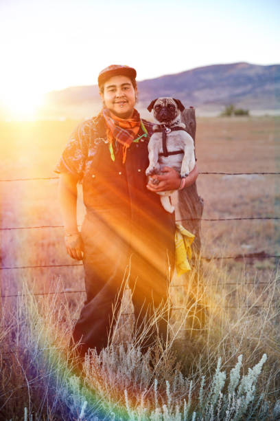 istock Young Hippie man holding pet pug 1221283688