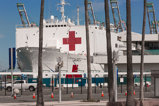 Los Angeles CA: 4/26/2020 - The USNS Mercy (T-AH-19) at the port of Los Angeles in San Pedro CA. USNS Mercy (T-AH-19) is the lead ship of her class of hospital ships in non-commissioned service with the United States Navy. Her sister ship is USNS Comfort (T-AH-20). She is the third US Navy ship to be named for the virtue mercy. In accordance with the Geneva Conventions, Mercy and her crew do not carry any offensive weapons, though defensive weapons are available. Attacking Mercy is a war crime.