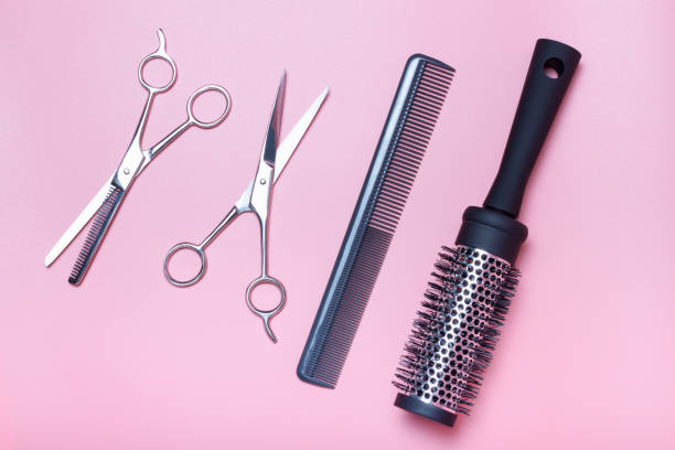istock Hairdressing scissors, comb and brushing on pink background, a view from above 1221287624