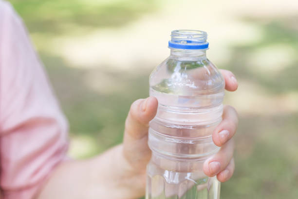 istock A hand holding a plastic bottle of water, close up 1221293504
