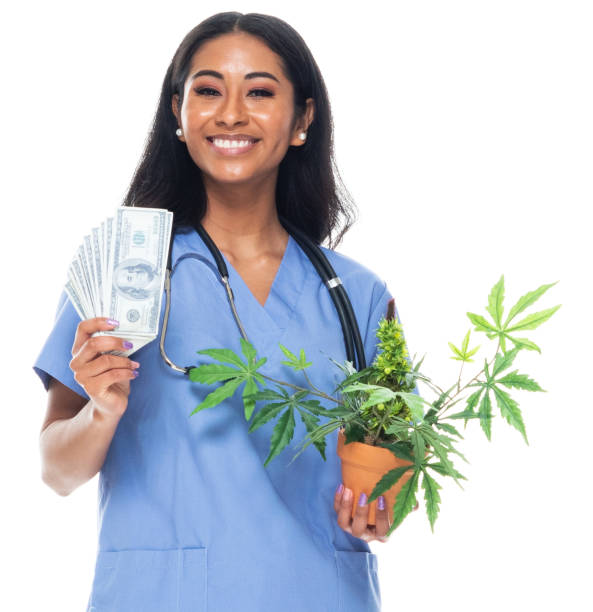 mujeres jóvenes de etnia latinoamericana e hispana de pie frente a fondo blanco y sosteniendo planta de cannabis - laughing women us paper currency isolated fotografías e imágenes de stock