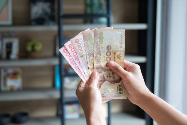 istock Hand giving stack of thousand bath Thai money with copy space 1221296281