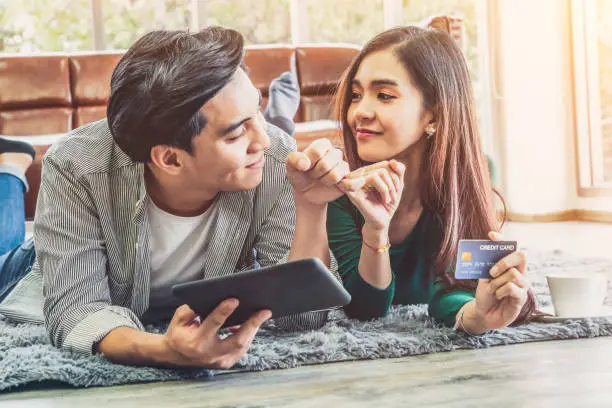 Photo of Young couple use credit card for online shopping