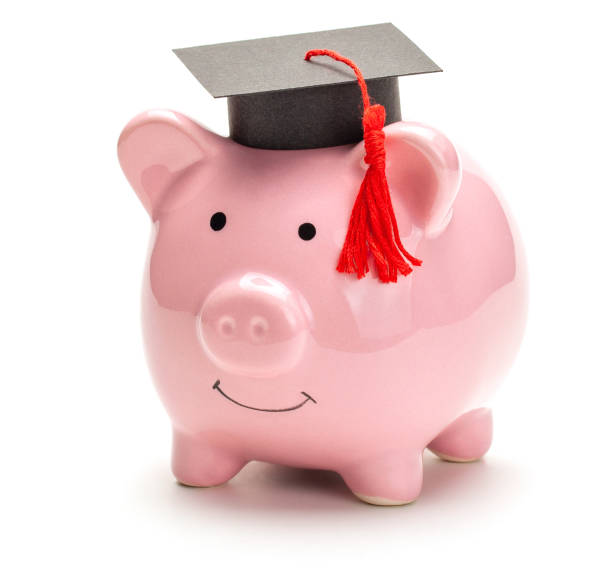 istock Piggy bank and black graduate hat 1221298598