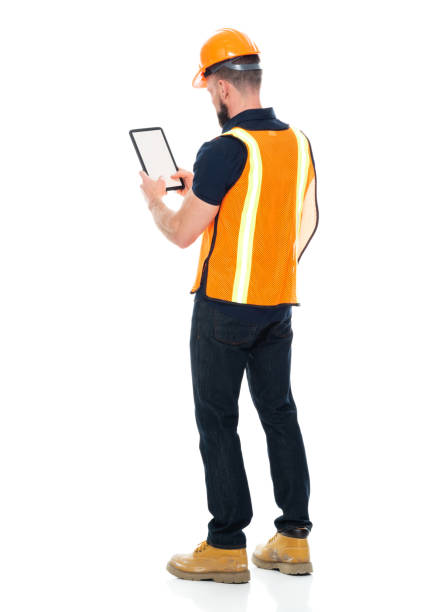 istock Manual worker repairing wearing pants and holding hammer and using touch screen 1221299542