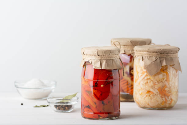 istock Various pickled fermented cultured vegetables in a glass jar for canning on a white table whith bay leaf, black pepper, coriander seeds, salt 1221301524