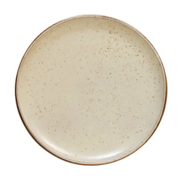 Empty rustic plate top cut out on white background. Round brown dish above view
