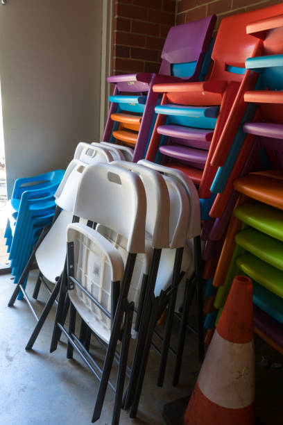 istock Colourful plastic chairs stacked in a room 1221303738