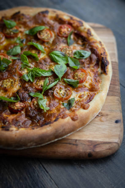 istock Real rustic home made pizza with fresh tomato and basil. 1221305599