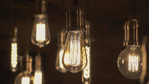 istock Vintage style light bulbs hanging from the ceiling. Old Edison light bulb. 1221306205