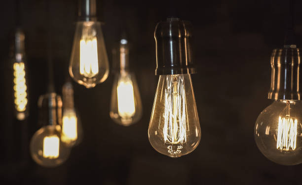 istock Vintage style light bulbs hanging from the ceiling. Old Edison light bulb. 1221306213
