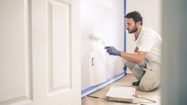 malarz maluje ścianę w domu, z rolką farby i białą farbą. remonty pokoi w domu. - house painter home improvement paint can painter zdjęcia i obrazy z banku zdjęć