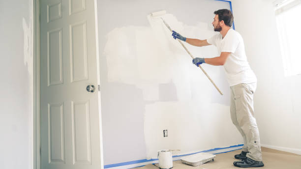 malarz maluje ścianę w domu, z rolką farby i białą farbą. remonty pokoi w domu. - paint brushing house painter wall zdjęcia i obrazy z banku zdjęć