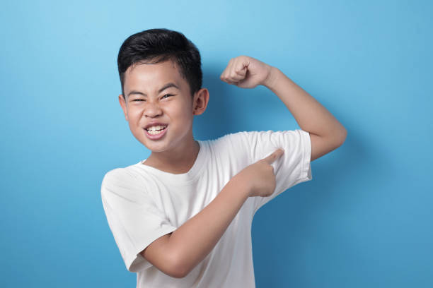 strong healthy asian boy shows his muscle - flexing muscles fotos imagens e fotografias de stock