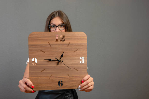 istock Attractive, emotional young woman  on dark background shows a clock - image 1221309084