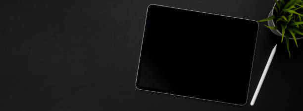 istock Top view of dark modern workspace with digital tablet, stylus pen, decoration and copy space 1221310637