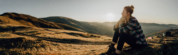 Lonely hiker resting on a mountain peak