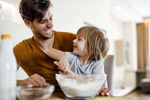 istock Happy single father and his son talking while making dessert in dining room. 1221312443
