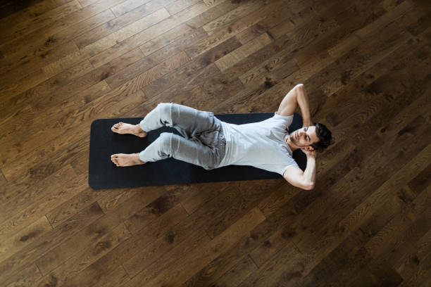 istock Above view of athletic man exercising sit-ups on exercise mat. 1221312709
