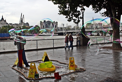 London/United Kingdom; 10/19/2013. Street artist on the banks of the River Thames offering his show to passersby