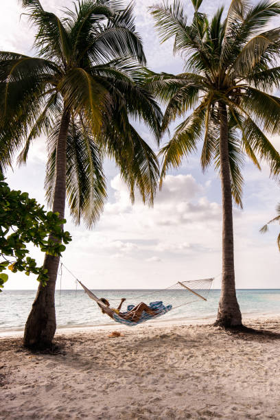 istock Woman relaxing in hammock during summer day on the beach. 1221315213