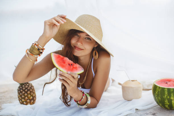 Woman on the Tropical Beach Eating Watermelon stock photo