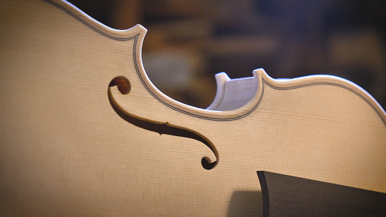 Macro close up of a violin in a workshop while a professional lutist is working