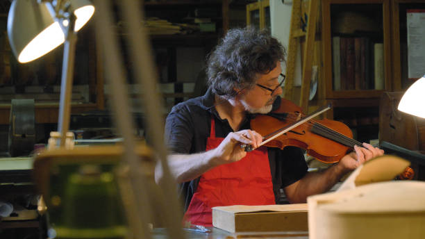 der professionelle bratschmeister spielt geige mit eigenen händen, verwendet in der werkstatt eine reine fichte, kiefer. - making craftsperson italian music musical instrument stock-fotos und bilder