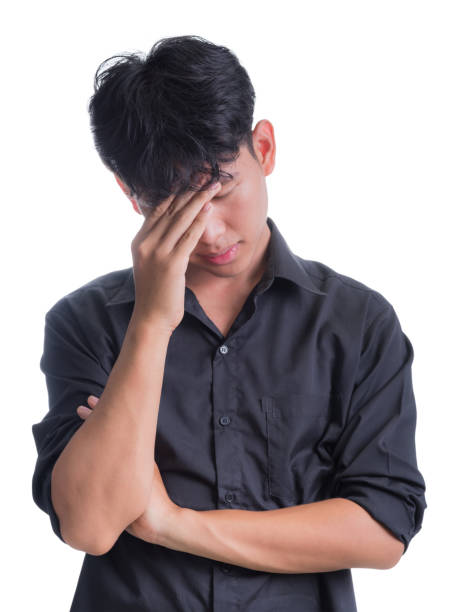 A young man in a long black shirt is worried about something. stock photo