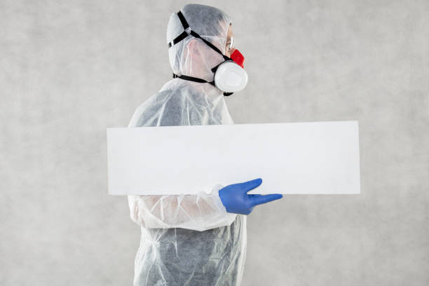istock virologist in protective clothing holds advertising space in his hands 1221322841