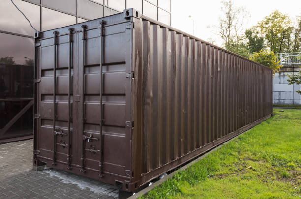 istock Dark brown cargo container stands near green grass 1221324889