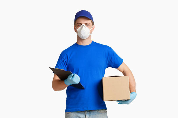 istock Courier in mask delivered parcel on white background 1221327563