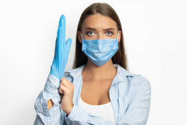 istock Woman Wearing Protective Gloves And Face Mask On White Background 1221327683