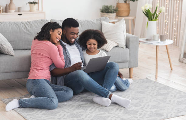 istock Black dad, mom, and little daughter using laptop at home together 1221329045