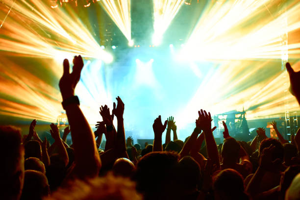 The audience watching the concert on stage in big concert club.