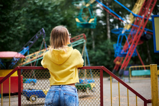 junge blonde frau im vergnügungspark - rollercoaster people amusement park ride red stock-fotos und bilder