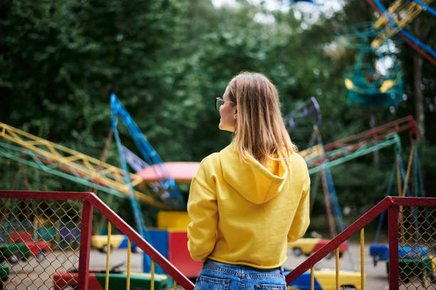 junge blonde frau im vergnügungspark - rollercoaster people amusement park ride red stock-fotos und bilder