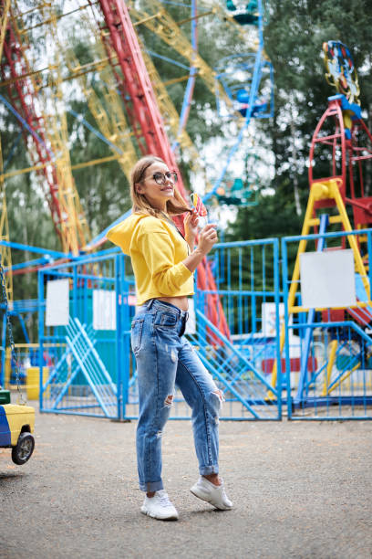 junge blonde frau im vergnügungspark - rollercoaster people amusement park ride red stock-fotos und bilder