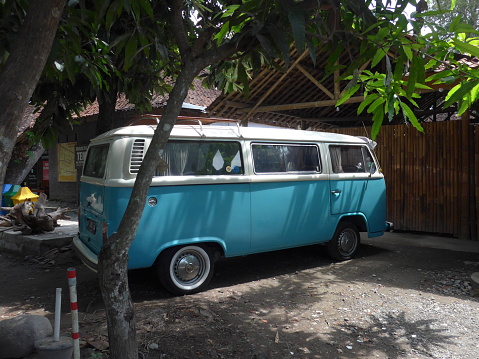 Yogyakarta, Indonesia - December 21, 2019: Volkswagen Combi from the sixties with blue and white color parked in front of a building